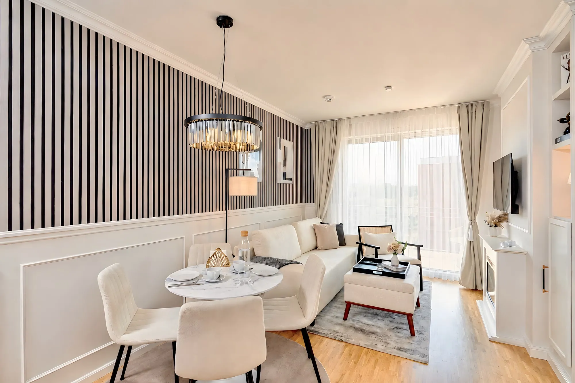 Heller Wohnbereich mit Streifenwand, Kronleuchter und Sitzbereich im Boutique-Apartment Art Déco in Dresden