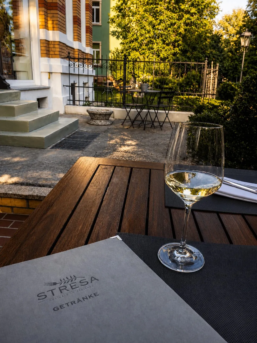 Weinglas und Getränkekarte auf der Terrasse des Restaurants Stresa in Dresden
